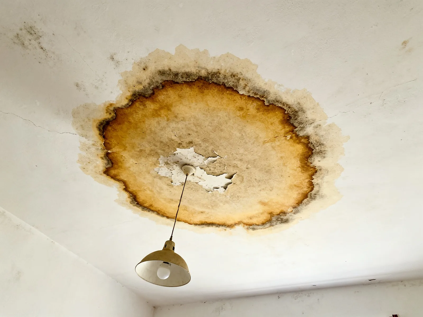 Mancha de humedad en el techo de una habitación bajo una terraza